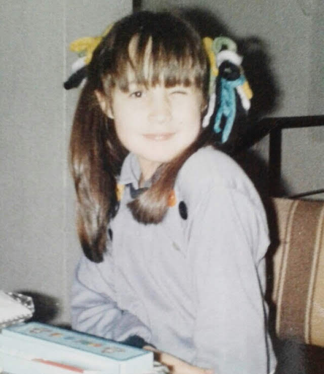 Catalina de niña, con colitas y moños, sonriendo