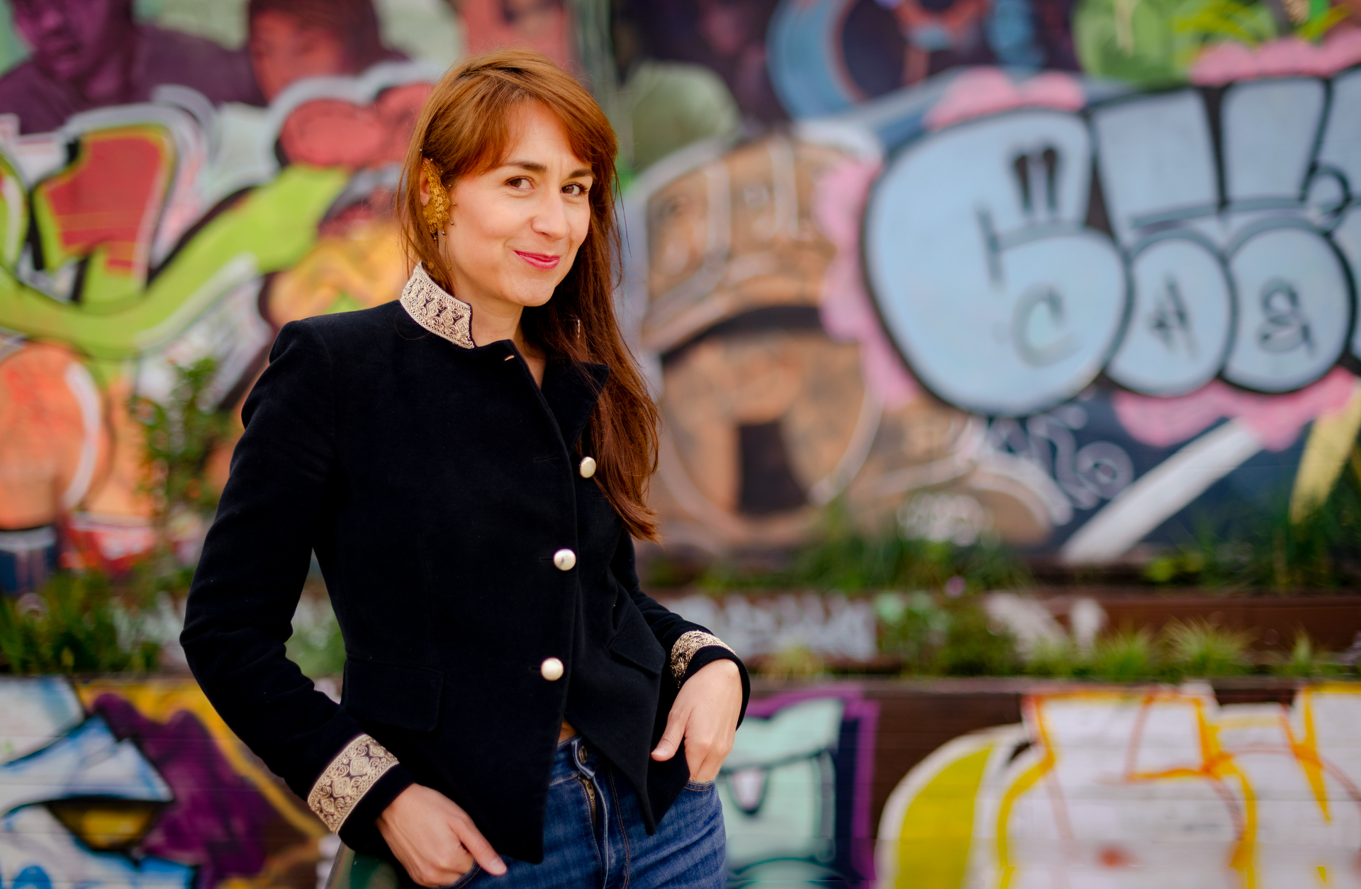 Retrato de Catalina Vega frente a un mural de grafiti